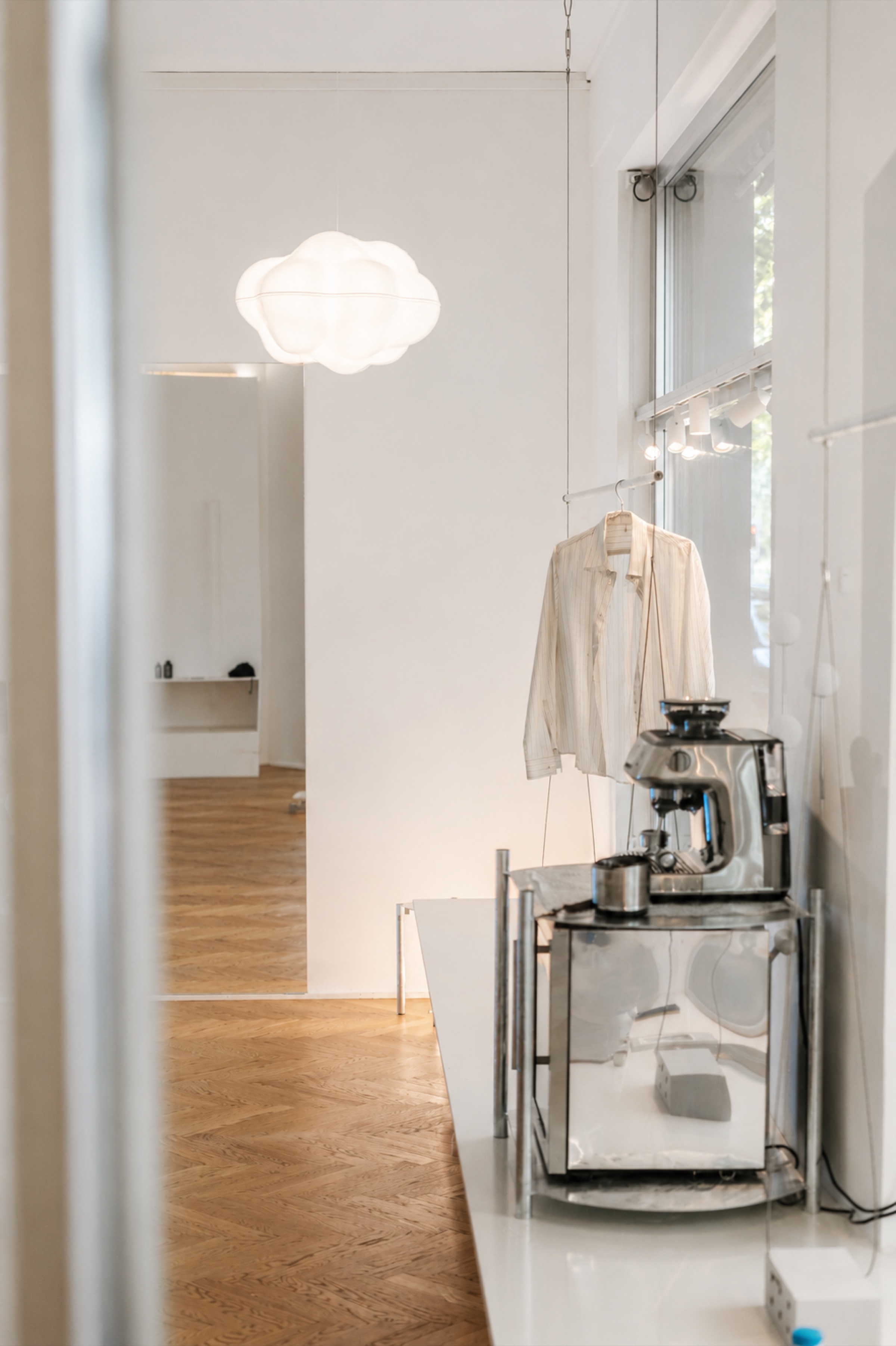 Kaffeeecke mit Siebträgermaschine unter einer wolkenförmigen Leuchte